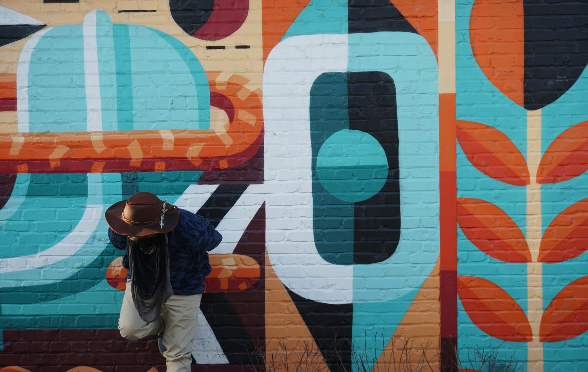 A person walking past a large, brightly painted street mural