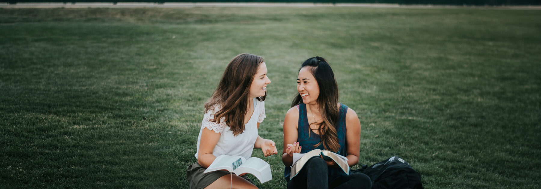 Friends reading and talking together outdoors